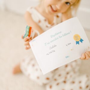 Photo d'un enfant montrant son diplôme d'arrêt de la tétine
